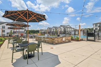 An outdoor patio with tables and umbrellas and a pool